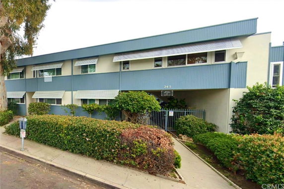 Front view of a two-story building with a gated entrance and horizontal window awnings.