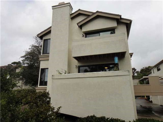 Front view of a two-story house with a chimney and balconies.