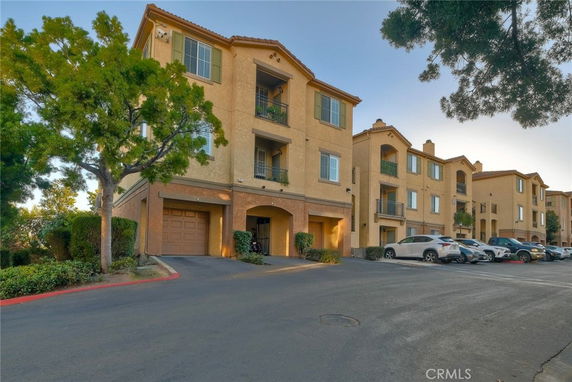 Front view of an apartment building with three stories and attached garages.