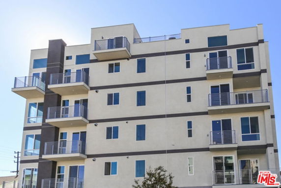 Front view of a multi-story apartment building with balconies.