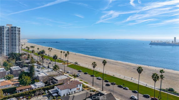 Panoramic view of a beachside area with buildings and palm trees along the coastline.