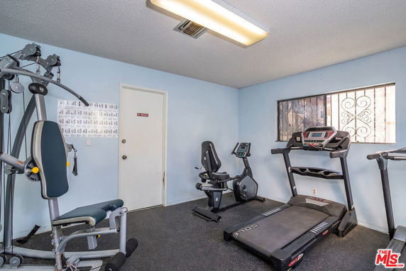Indoor gym area with exercise equipment including a treadmill and stationary bike.