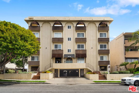 Front view of a multi-story apartment building with balconies.