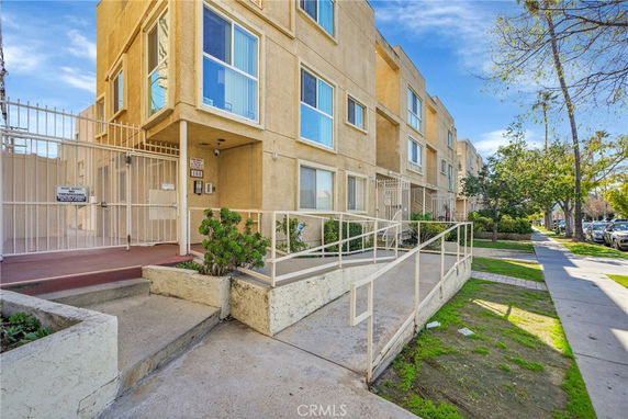 Front view of a multi-story residential building with a gated entrance.