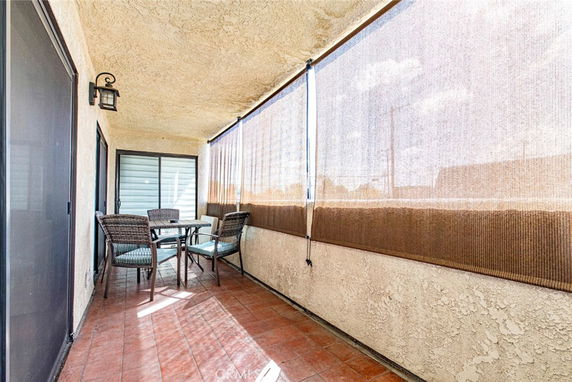 Covered rooftop area with a small table and chairs.
