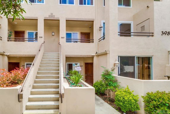 Front view of a multi-level residential building with a staircase leading to the upper level.
