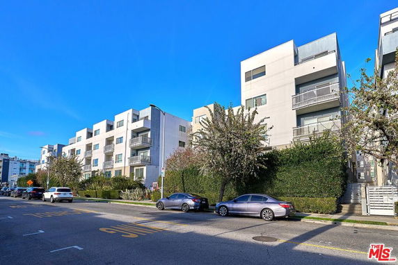 Front view of a multi-story apartment building with balconies.