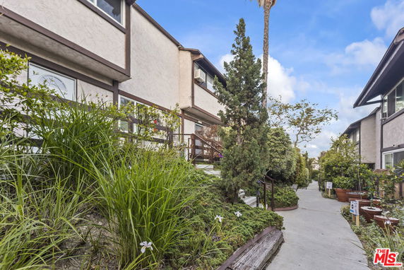 Front view of two-story residential buildings with pathway and greenery.