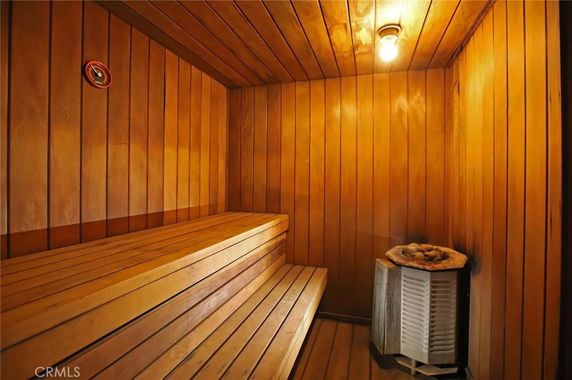 Interior view of a wooden sauna room with benches and a heater.