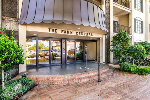 Front view of a building entrance with glass doors and a canopy.