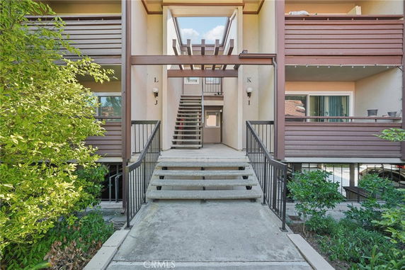 Front view of a multi-story residential building entrance with stairs.