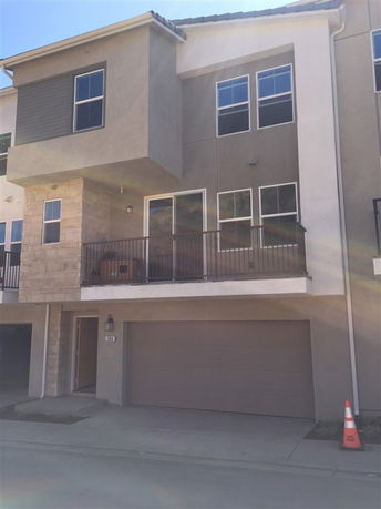 Front view of a multi-story house with a garage and balcony.