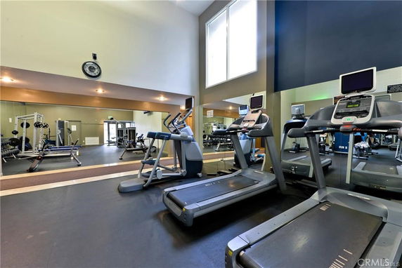 Interior of a fitness gym with treadmills and weightlifting equipment.