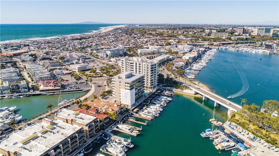 Wide angle view of urban coastal area with marina and buildings.