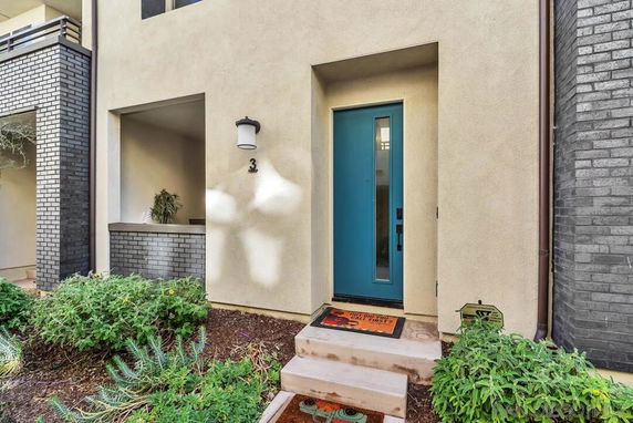 Front view of a modern house with a blue door and brick accents.