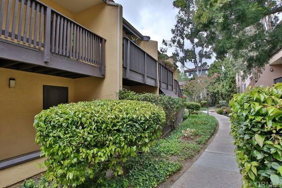 Front view of a residential building with balconies and a walkway.