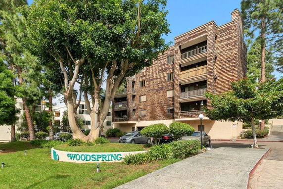 Front view of a multi-story apartment building with a distinctive wood-paneled exterior.