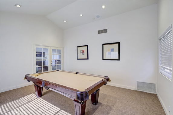 Room with a pool table and framed pictures on the wall.