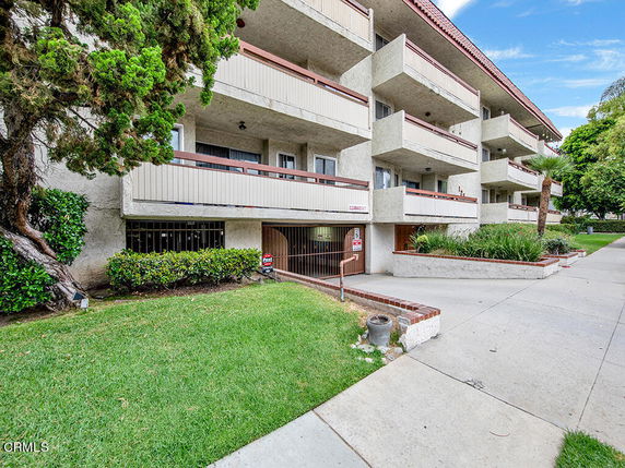 Front view of a multi-story building with balconies and ground-level access.