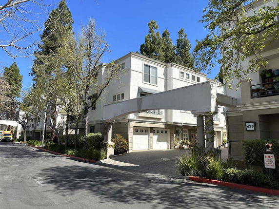 Front view of a multi-story residential building with garages and balconies.