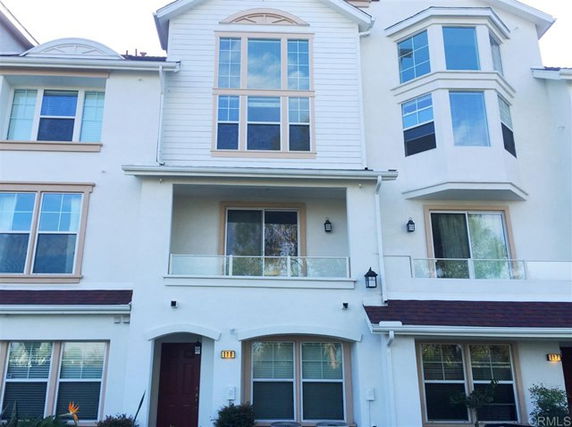 Front view of a three-story townhouse with multiple large windows and balconies.