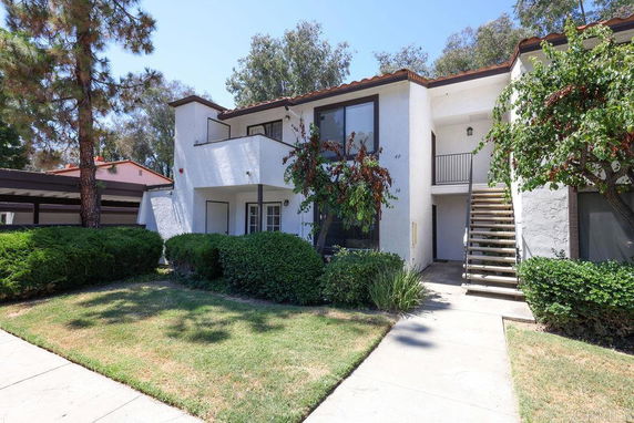 Front view of a two-story apartment building with exterior stairs and balconies.