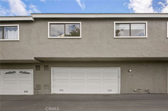 Front view of a building with two garage doors and windows on the upper floor.