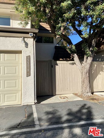 Front view of a building with a garage and fence.