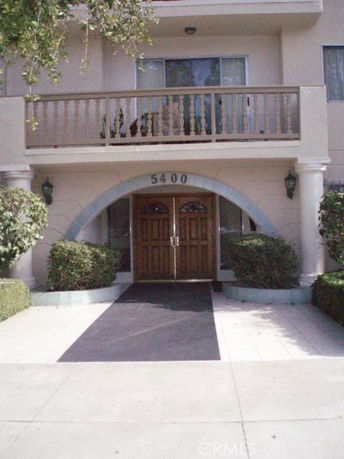 Front view of a building with an arched entrance and balcony.