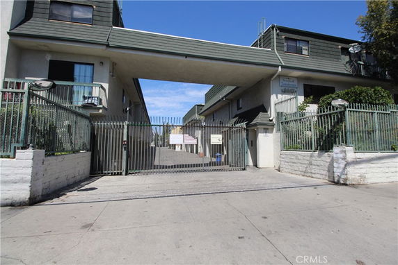 Front view of a gated residential complex with two-story buildings.