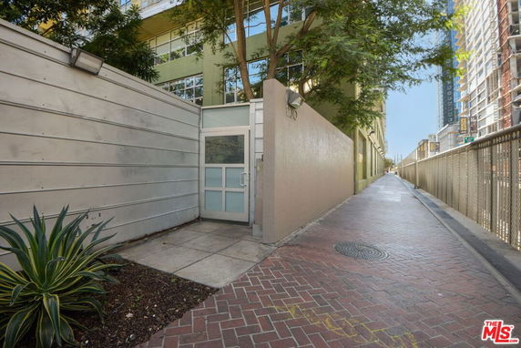 Front view of an entrance with a metal gate and a walkway along a building.