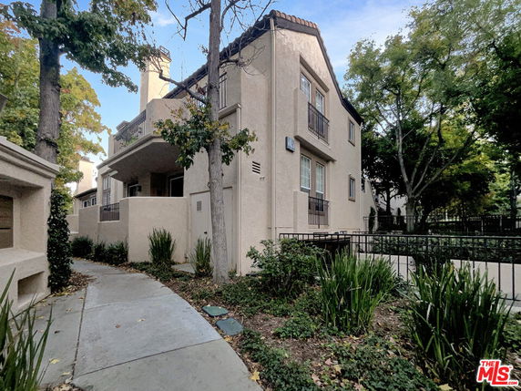 Exterior view of a two-story house with a covered entrance and balcony.