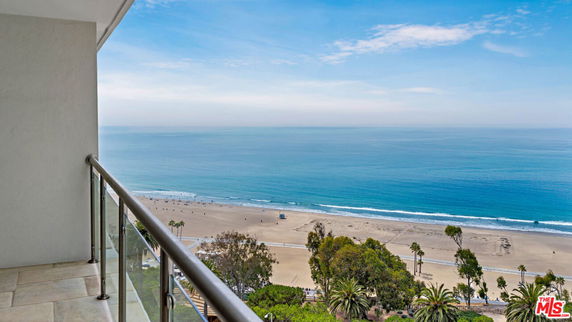 Panoramic view from a balcony overlooking a beach and the ocean.