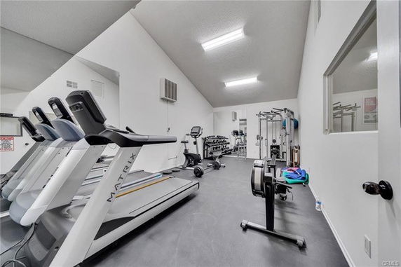 Interior of a gym with various exercise equipment including treadmills and weights.