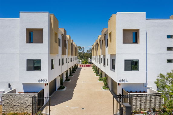 Front view of two parallel multi-story buildings with a central walkway.