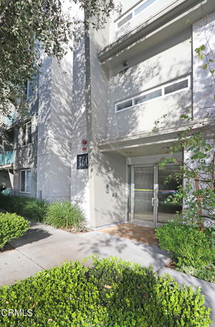 Front view of a multi-story building with a glass entrance door.