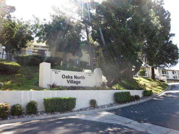Front view of Oaks North Village complex entrance with building in the background.