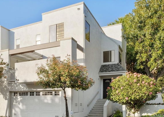 Front view of a modern two-story house with a garage and a small balcony.