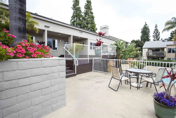 Outdoor area with swimming pool and patio furniture near a building.