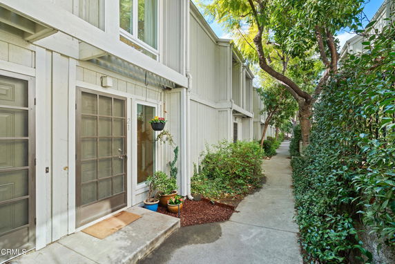 Front view of a multi-story townhouse with entrance doors and windows.