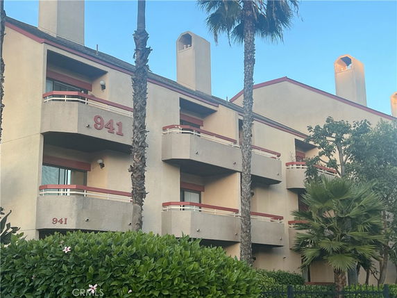Front view of a multi-story building with balconies and visible address number 941.