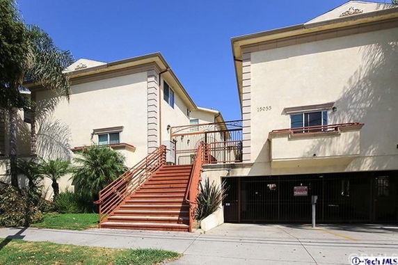 Front view of a multi-story building with a staircase leading to the entrance.