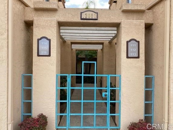 Entrance view of a building with numbered plaques and a gated entrance.