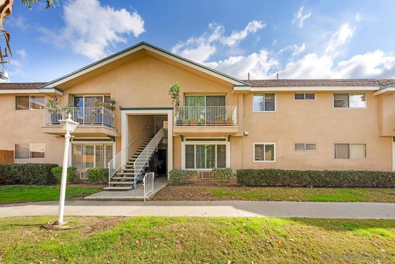Front view of a two-story apartment building with balconies and central staircase.