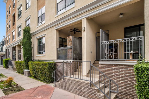 Front view of a multi-story building with a small porch and stairs.