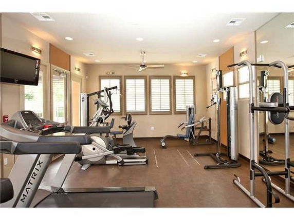 Indoor gym area with fitness equipment and mirrors.