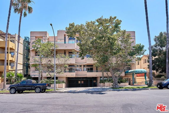 Front view of a multi-story residential building with balconies.