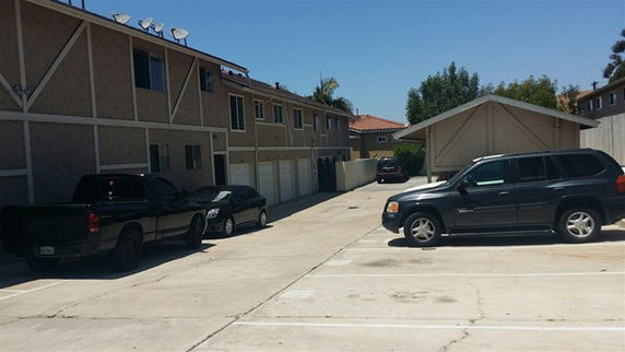 Outdoor parking area with multiple vehicles parked.
