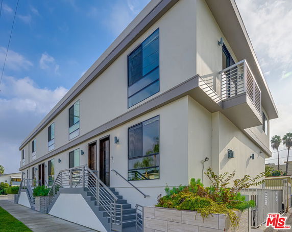 Front view of a modern two-story building with large windows and a small balcony.