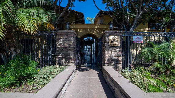 Front view of a building with stone columns and gated entrance.